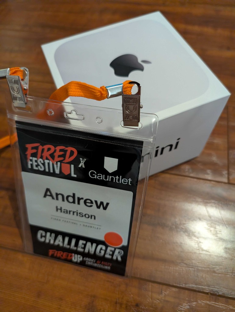 Andrew Harrison's Fired Festival Challenger badge resting against the Mac Mini prize box